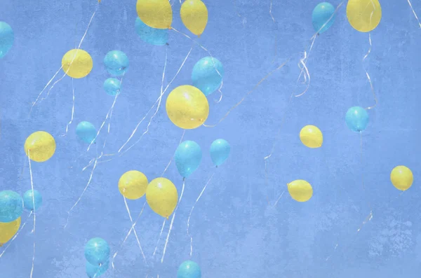 Veel gele en blauwe ballonnen vliegen in de lucht. Grunge achtergrond met ballonnen. Vakantie evenement — Stockfoto