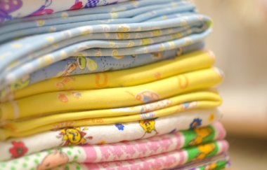 Stack of swaddling bands. Close-up of corner a laid colored laundry. Heap of folded linen of various colors. clipart