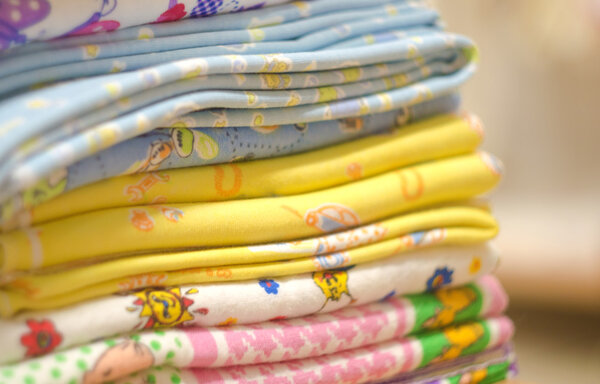 Stack of swaddling bands. Close-up of corner a laid colored laundry. Heap of folded linen of various colors.