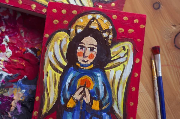The angel is drawn on a board in ancient style of painting. Christmas photo.