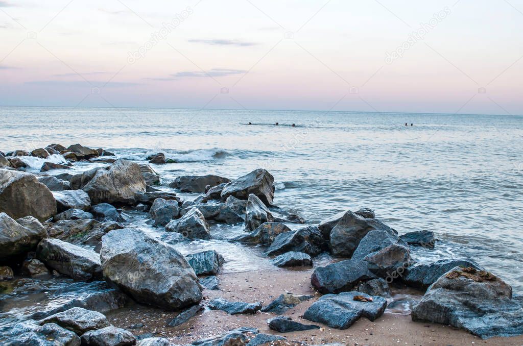 Sea stones boulders sandy shore. Natural landscape photo.