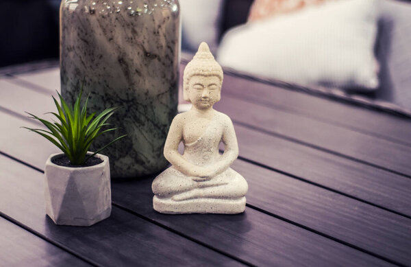 Buddha statue on gray table. Modern interior in Hugge style.