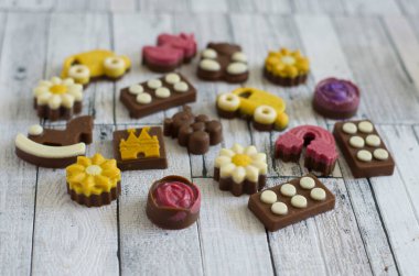 Kerob 'un araba şeklindeki el yapımı çikolataları, bir çiçek, bir ayı, bir çekirge. Doğal tatlıların natürmort fotoğrafı..