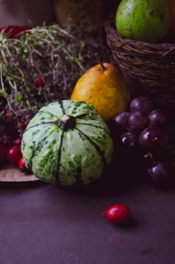 Balkabağı, üzüm, gül kalçası, kekik, armut ve elmanın sonbahar kompozisyonu. Durgun fotoğraf.