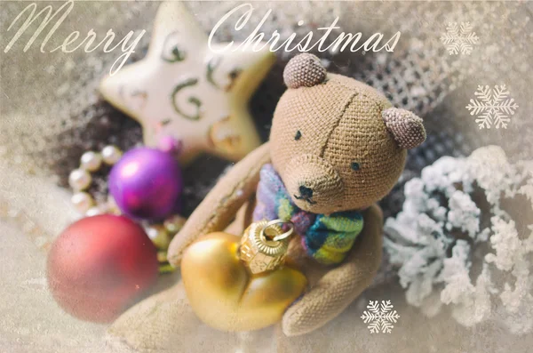 Рождественская открытка с медведем Тедди, ожерельем, сосновым шишкой и елочными игрушками. Поздравительная открытка. Обложка, обертка — стоковое фото