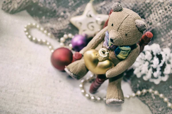 Tarjeta de Navidad con osito de peluche, collar, cono de pino, juguetes de árbol de Navidad para su diseño. Grunge fondo de Navidad . — Foto de Stock