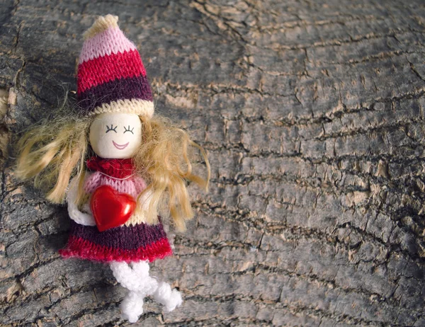 Małe dzieci postać lalek, trzyma serca na tle szorstka kora drewniana z kopia miejsce. Ręcznie robione lalki — Zdjęcie stockowe