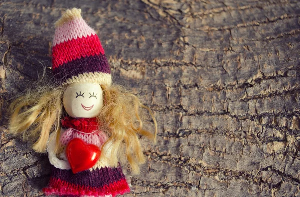 Małe dzieci postać lalek, trzyma serca na tle szorstka kora drewniana z kopia miejsce. Ręcznie robione lalki — Zdjęcie stockowe