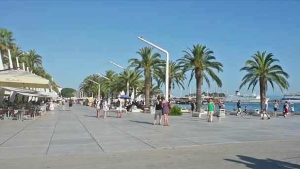 Lidé, procházky a odpočinek na letní ráno na promenádě Split, Chorvatsko. — Stock video