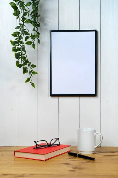 Ein Leerer Schwarzer Rahmen Und Ein Efeu Auf Weißem Holzgrund — Stockfoto