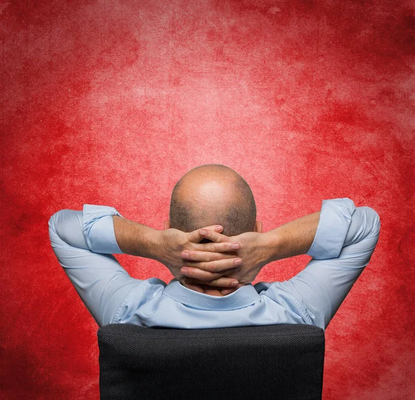 a relaxed man shot from behind with a red background