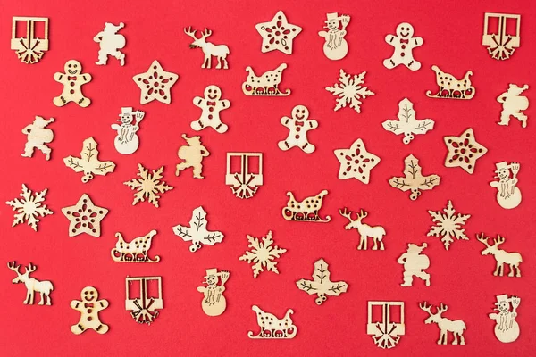 Eine Textur Aus Kleinen Hölzernen Weihnachtssymbolen Auf Rotem Hintergrund — Stockfoto