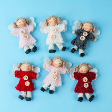 Mavi arka planda küçük el yapımı bebekler.