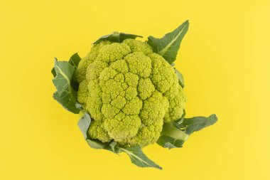 Sarı bir yüzeyde yeşil bir karnabahar.