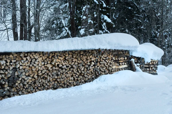 The piles of wooden logs covered with snow in winter — Stock Image Piles Wooden Logs Covered Snow Winter Stock Photo