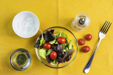 Bir kase karışık salata ve domates giydir.