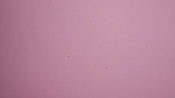 Der Fall Kleiner Farbiger Zuckerbällchen Auf Eine Rosa Oberfläche — Stockvideo