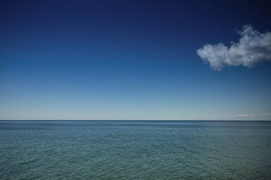 Denizin üzerindeki mavi gökyüzünde bir bulut