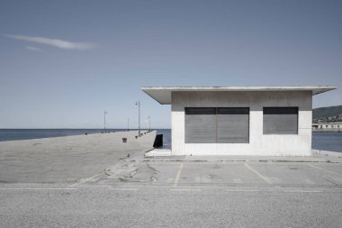Kapalı bir bina ve güneşli bir günde deniz kıyısındaki iskele.