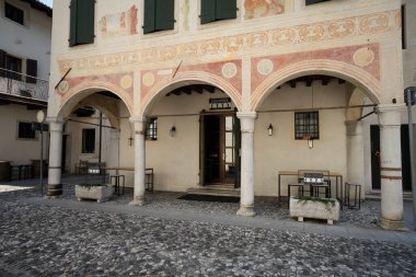 Spilimbergo, İtalya. 3 Haziran 2021. Doğu kulesine bitişik binadaki dekorasyonlara bak. Tarihi merkezdeki eski şehir kapısı.