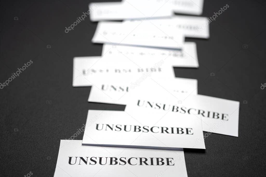 Some tickets with the word Unsubscribe arranged on the table, as a concept of the choice to cancel subscriptions