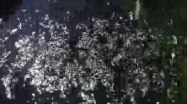 Işığa karşı görünen bir havuza düşen su akıntısı.