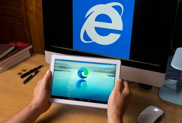 Udine, İtalya, Ağustos 2021 Bir tablet ekranda yeni Microsoft Sınır tarayıcısının sembolü Bir bilgisayar ekranında Internet Explorer sembolü.