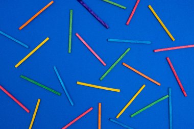 Mavi bir yüzeyde çok renkli çubuklar var.