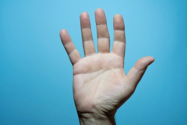 Mavi arka planı olan bir adamın avuç içi.