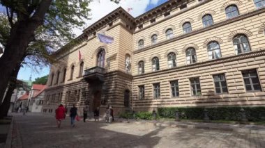 Riga, Letonya. Ağustos 2021 'de şehir merkezinde, Letonya parlamentosunun merkezi olan Saeima binasının önünde yürüyüş yapan insanlar görülüyor..