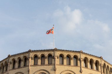 Oslo, Norveç. Eylül 2021 'de şehir merkezindeki parlamento binasının çatısında Norveç bayrağı dalgalanıyor.