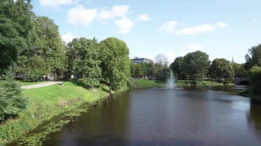 Riga, Letonya. Ağustos 2021 'de şehir merkezindeki bir parktaki gölette bir çeşme.