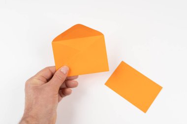 Beyaz bir yüzey üzerinde açık turuncu bir zarf.