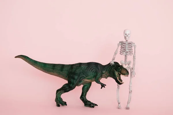 Dinossauro Verde Esqueleto Humano Fundo Rosa Foco Seletivo — Fotografia de Stock