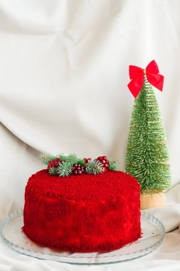 Gri arka planda yeşil ağaç ve nar tohumlarıyla süslenmiş kadife pasta.