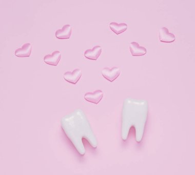Üst manzara düz iki diş pembe kalpler pembe pastel arka plan yatıyordu. Ağız bakımı ve Sevgililer Günü konsepti.
