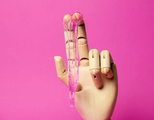 ピンクの液体ペーストピンクの背景を滴下木製の手を閉じます 脱毛とセックスの概念 — ストック写真