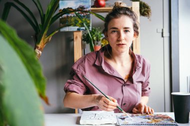 Sanat stüdyosunda güzel bir kadın çiziyor. Hobi ve sanat konsepti.