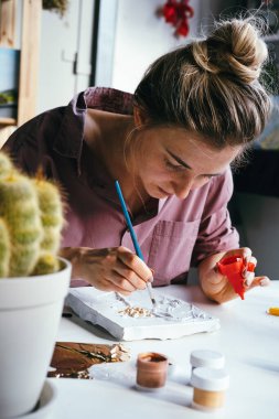 Genç ve güzel bir kadın alçı ve beyaz boyayla çalışıyor. DIY ve hobi konsepti.