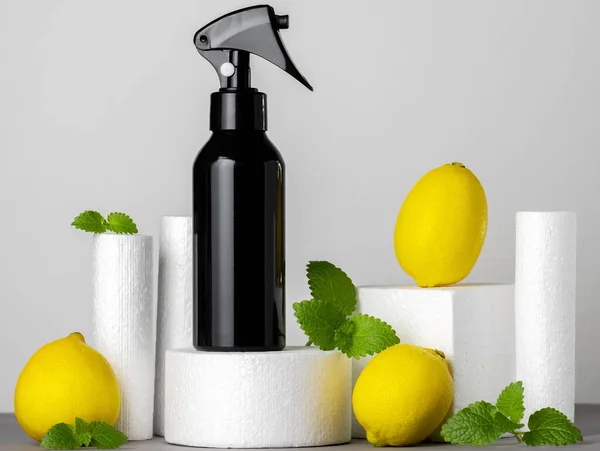 Limon ve nane yapraklı gri arkaplanlı bir ürün standındaki boş spreyleri taklit et