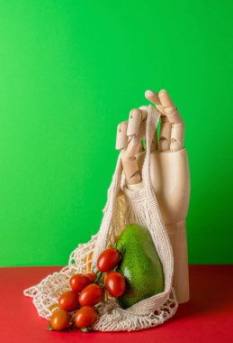 Ahşap eli, ip torbası ve yeşil arka planda taze sebzeleri olan modern bir hayat.