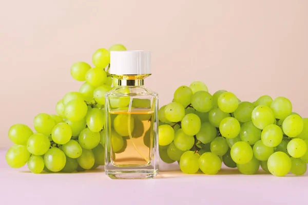 Yeşil üzüm arkaplanlı parfüm şişesi.