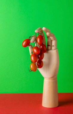 Yeşil arka planda domatesler ve ahşap elle modern, durgun yaşam