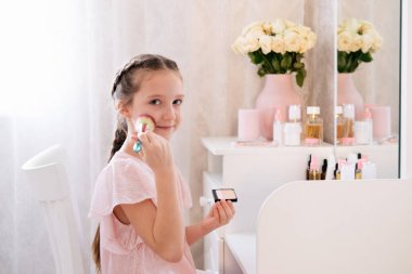 Yatak odasında makyaj yapan sevimli küçük bir bayan. Hafif ve havadar portre.