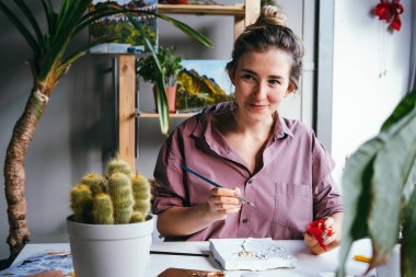 Genç ve güzel bir kadın alçı ve beyaz boyayla çalışıyor. DIY ve hobi konsepti.