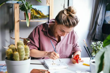 Genç ve güzel bir kadın alçı ve beyaz boyayla çalışıyor. DIY ve hobi konsepti.