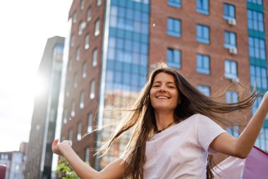 Şehrin arka planında güzel, genç bir esmer. Mutluluk ifadesi duygusal yaşam tarzı portresi.
