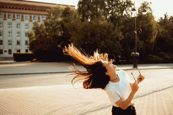 Happy young brunette woman enjoying summer in a city. Real woman urban portrait.