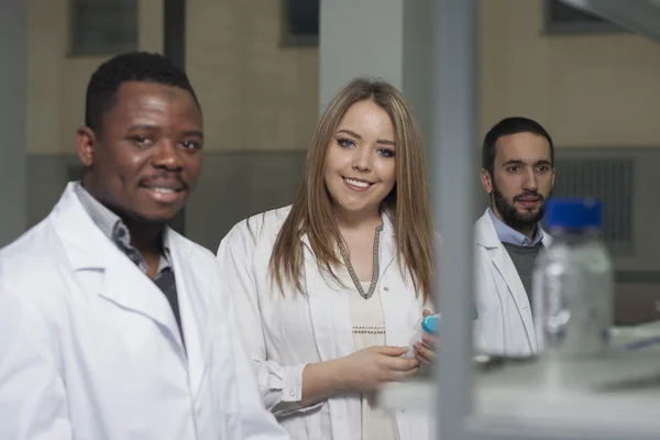 Grup genç tıbbi işçilerin are çalışma laboratuarda laboratuar tekniği