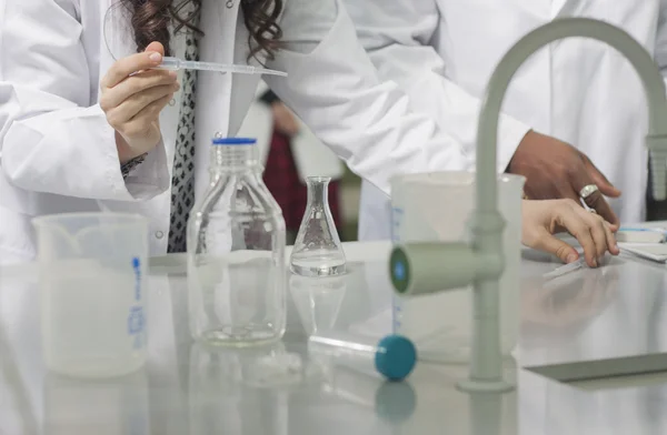 Grup genç tıbbi işçilerin are çalışma laboratuarda laboratuar tekniği